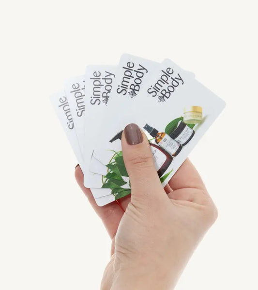 A person holding 5 Simple Body physical gift cards
