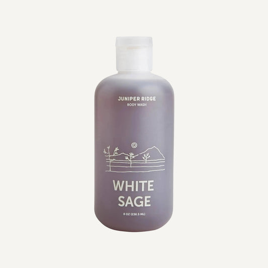 A bottle of Juniper Ridge White Sage body wash, featuring a frosted translucent bottle with a white cap and white text, set against a plain white background.