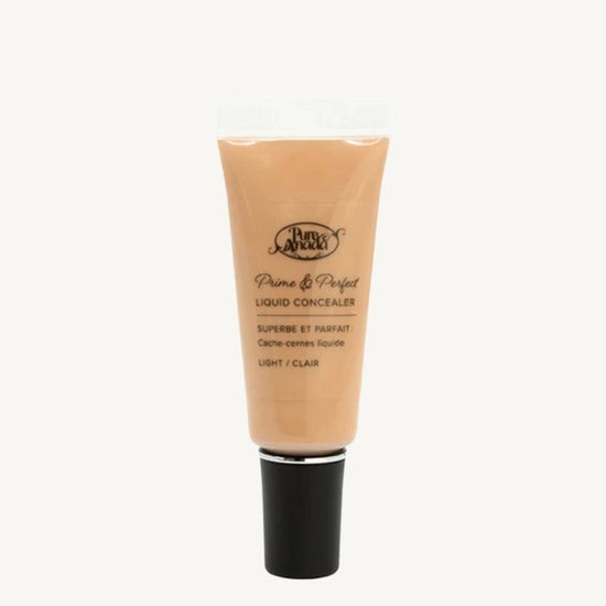 A photo of Pure Anada's Liquid Concealer in Light which is a warm beige color on a tan background.