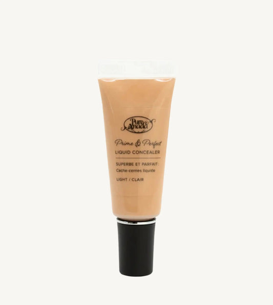 A photo of Pure Anada's Liquid Concealer in Light which is a warm beige color on a tan background.