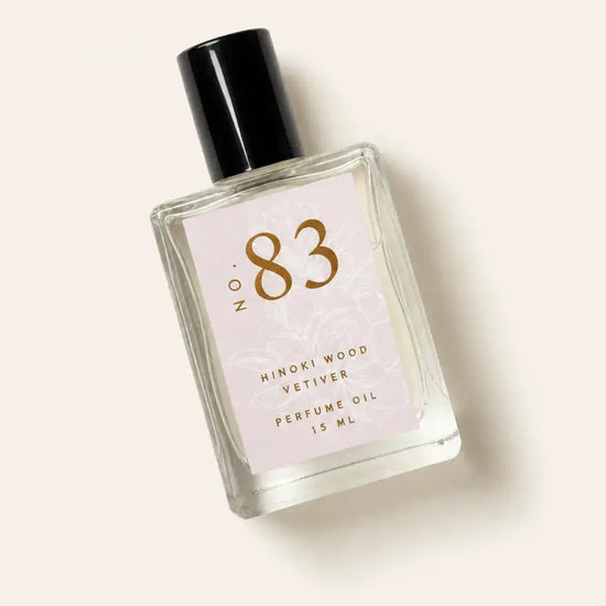 A bottle of Luxe Perfume No. 83 with a beige label that reads "Hinoki Wood Vetiver" on a beige background.