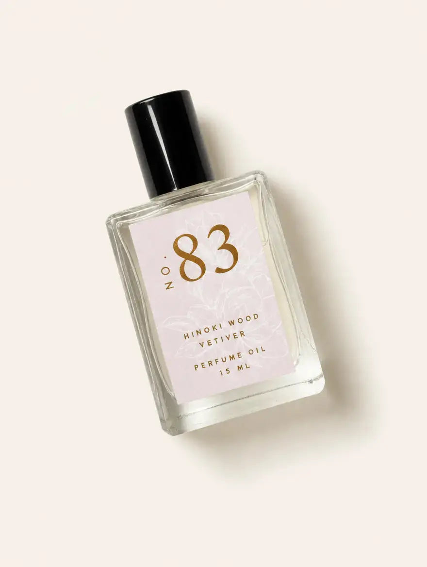 A bottle of Luxe Perfume No. 83 with a beige label that reads "Hinoki Wood Vetiver" on a beige background.