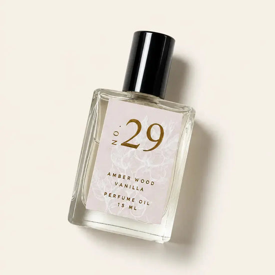 A bottle of Luxe Perfume No. 29 with a beige label that reads "Amber Wood Vanilla" on a beige background.