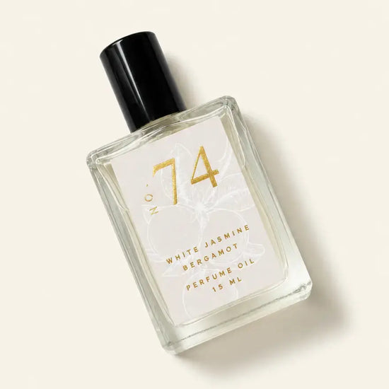 A bottle of Luxe Perfume No. 74 with a beige label that reads "White Jasmine Bergamot Perfume Oil" on a beige background.