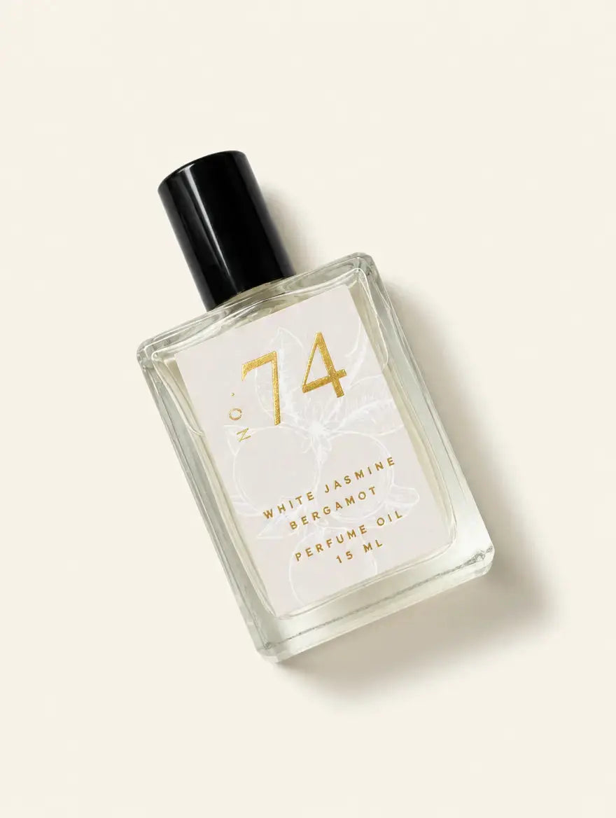 A bottle of Luxe Perfume No. 74 with a beige label that reads "White Jasmine Bergamot Perfume Oil" on a beige background.