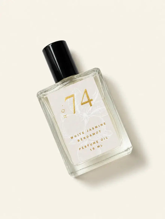 A bottle of Luxe Perfume No. 74 with a beige label that reads "White Jasmine Bergamot Perfume Oil" on a beige background.