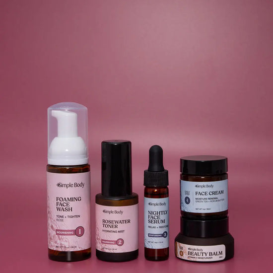 A Mini Starter Skincare kit for normal to dry skin including a Foaming Face Wash, Rosewater Toner, Nightly Face Serum, Face Cream, and Beauty Balm on a rosey pink background.