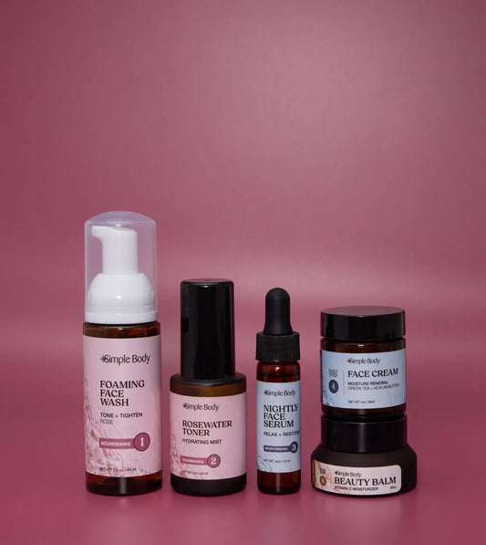 A Mini Starter Skincare kit for normal to dry skin including a Foaming Face Wash, Rosewater Toner, Nightly Face Serum, Face Cream, and Beauty Balm on a rosey pink background.