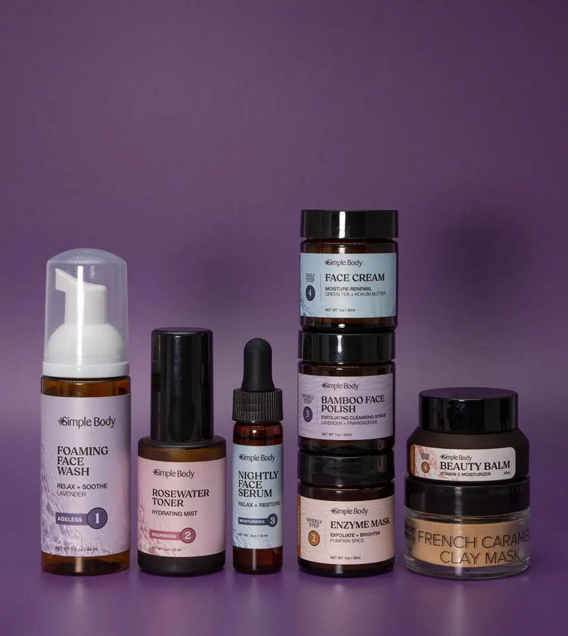 A Mini Starter Skincare kit for mature skin including a Foaming Face Wash, Rosewater Toner, Nightly Face Serum, Face Cream, Bamboo Face Polish, Enzyme Mask, Beauty Balm, and Clay Mask on a purple background.