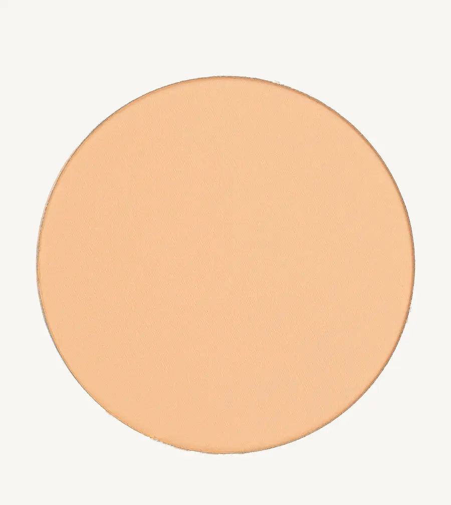 A photo of Pure Anada's Pressed Sheer Foundation in Very Fair which is a medium beige with light overtones and a warm feel on a tan background.