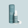 Thistle Farms Relief essential oil roll-on bottle and packaging on a light blue background