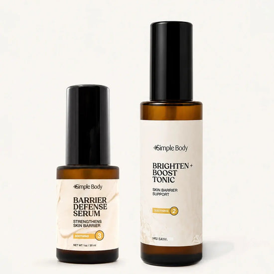 Two Simple Body skincare bottles on a clean white background: a smaller amber bottle of Barrier Defense Serum with a black cap and cream label, and a taller amber bottle of Brighten + Boost Tonic with a black cap and white label.