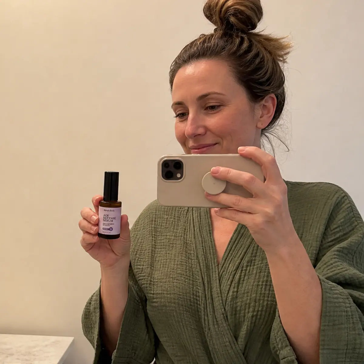 A woman takes a selfie with Simple Body Age Defense Serum. AI