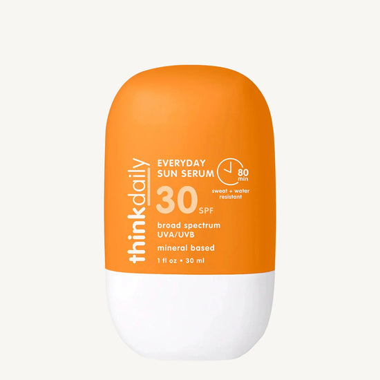 Orange and white sunscreen bottle with 'think daily' branding on a white background