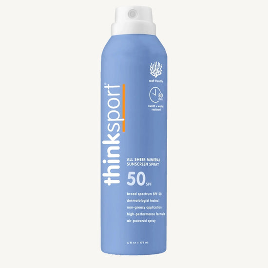 Blue sunscreen spray bottle with white cap on a white background