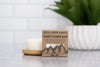 Rock Creek Soaps conditioner bar packaging on a surface with a candle and plant in the background