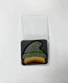 A green marbled lymphatic massage tool with a yellow bristle brush resting on a black insert inside a clear plastic case, shown on a plain white background.