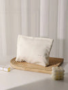 Beige corduroy cosmetic bag on a wooden stand with a minimal background