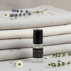 Roll-on bottle of lavender perfume with lavender flowers and fabric in the background