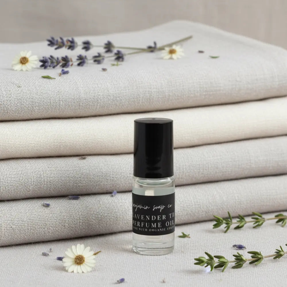 Roll-on bottle of lavender perfume with lavender flowers and fabric in the background