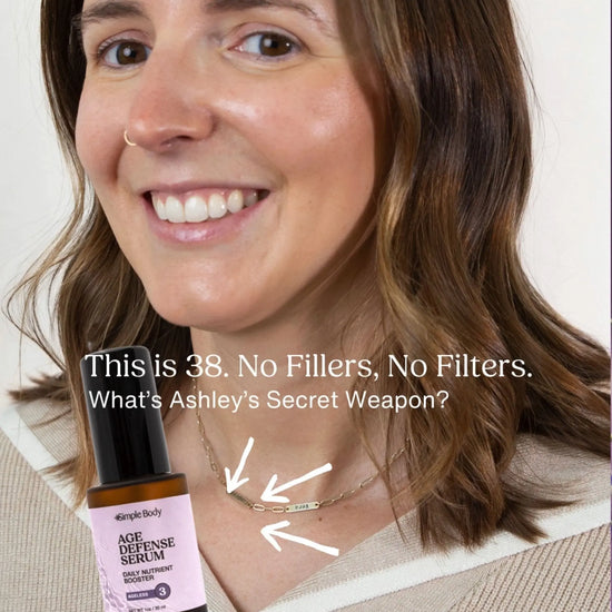 A woman smiling with beautiful skin and a bottle of Simple Body Age Defying Serum a testimonial on a white background.