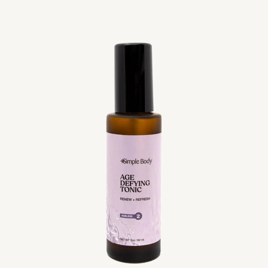 An amber bottle of Simple Body Age Defying Tonic on a tan background