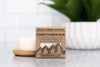 Rock Creek Soaps conditioner bar packaging with a candle and plant in the background