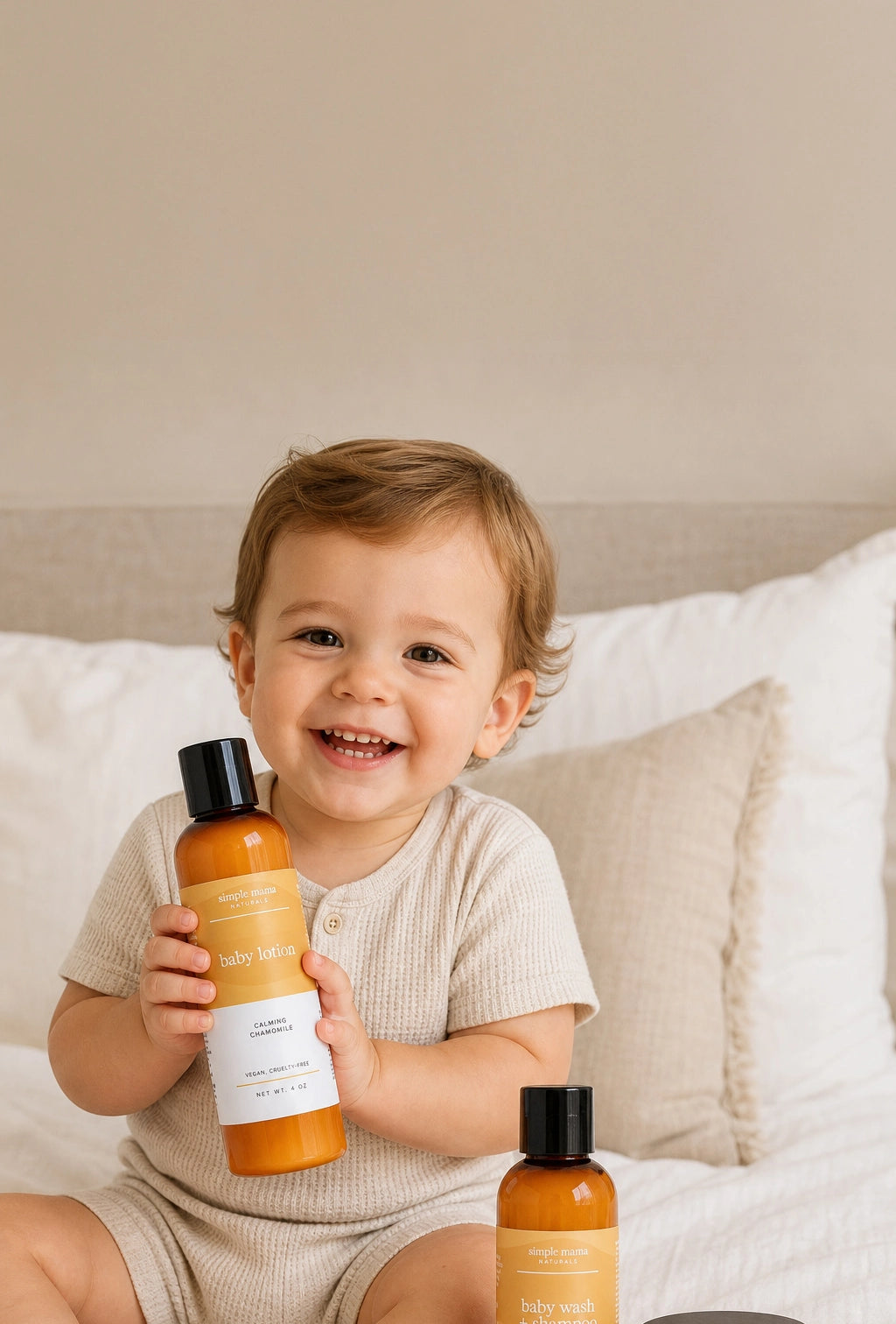 Baby holding Simple Mama Baby Lotion smiling with a beige background