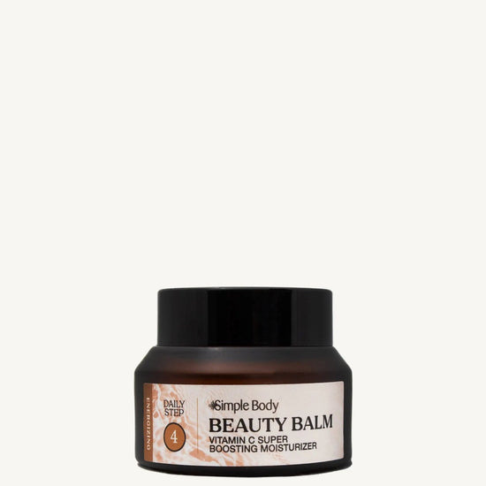 Beauty balm jar with black lid and peach colored label on a light tan background