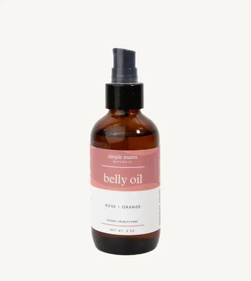 Bottle of Simple Mama belly oil with a pink label on a tan background