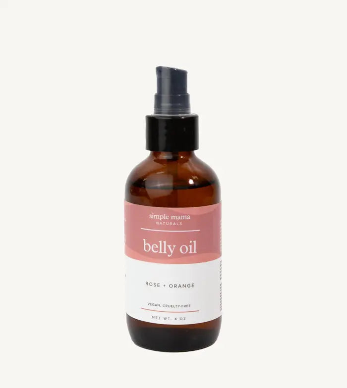 Bottle of Simple Mama belly oil with a pink label on a tan background
