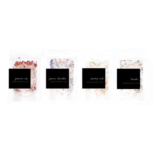 Four small containers with decorative labels on a white background
