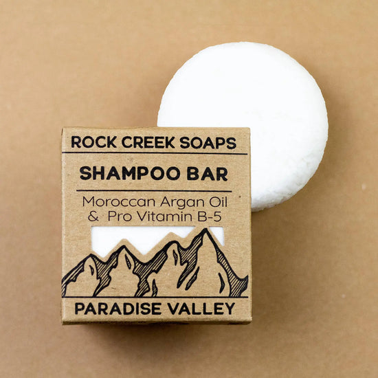 Rock Creek Soaps shampoo bar with packaging on a brown background