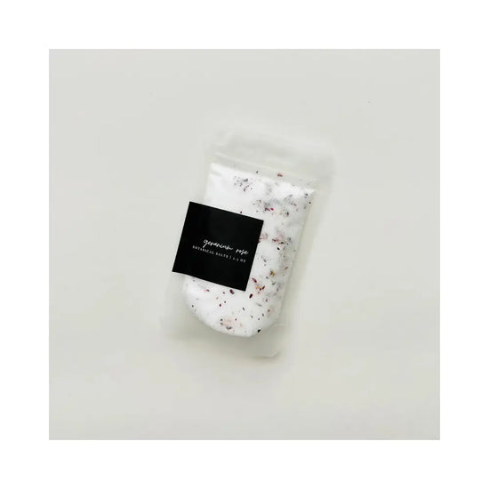 Packaged bath salt with a label on a light gray background