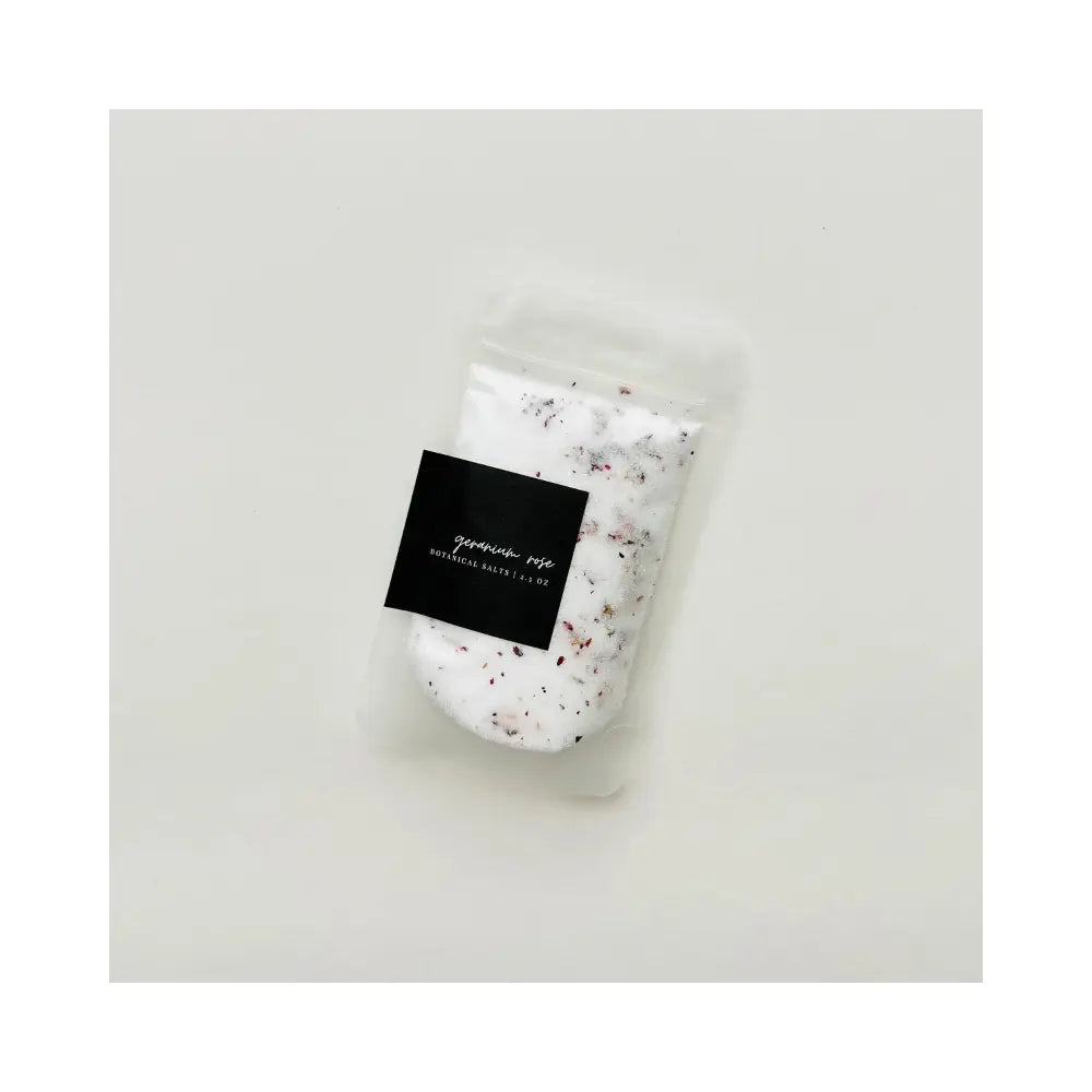 Packaged bath salt with a label on a light gray background