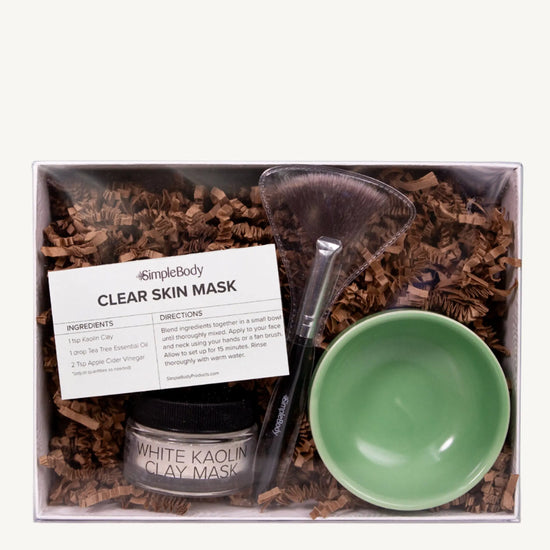 A photo of Simple ody's Clay Mask Kit which includes a recipe card, fan brush, Clay and bright green bowl packaged in a white gift box
