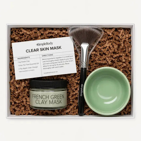 A Simple Body Clay Mask Kit with French Green Clay, a recipe card, fan brush and green bowl with kraft crinkle in a gift box.