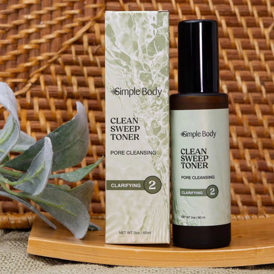 Simple Body Clean Sweep Toner bottle and packaging on a woven surface with a plant.