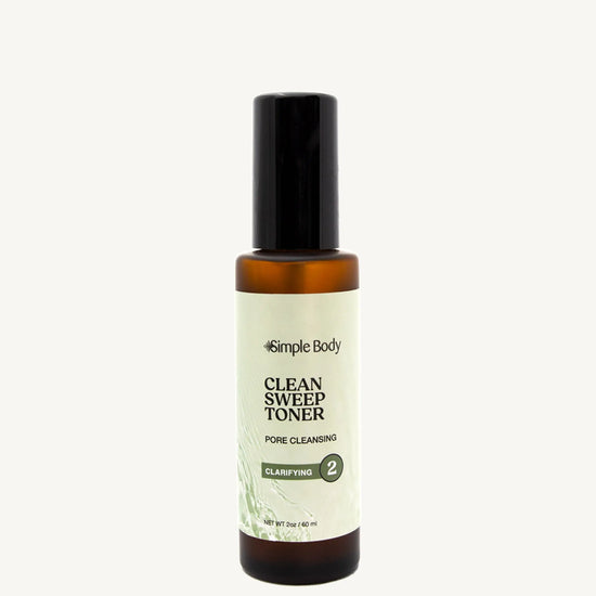 Bottle of Simple Body Clean Sweep Toner on a tan background