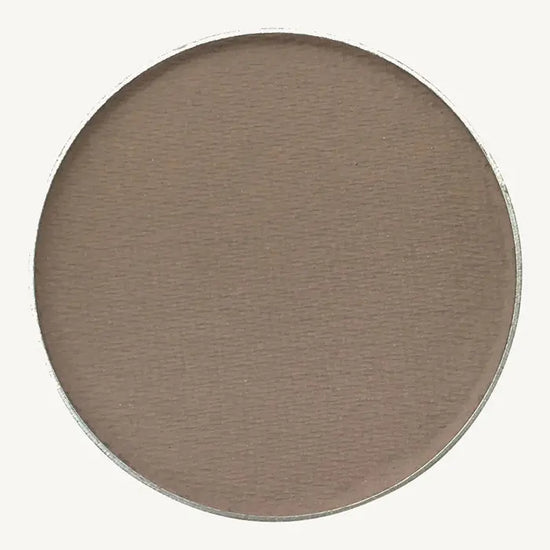 A photo of Pure Anada's Pressed Eye Shadow in Clouded which is a cool brown on a tan background.