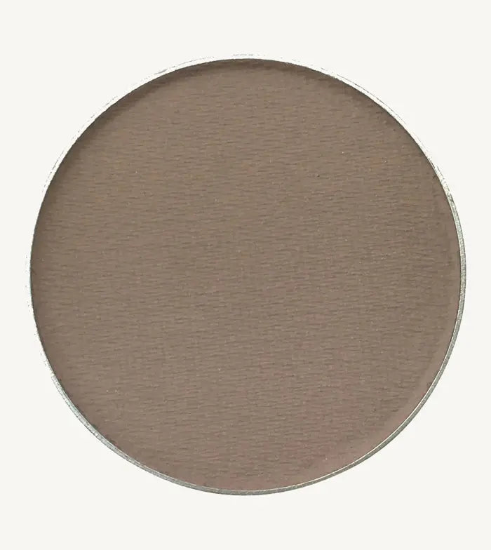 A photo of Pure Anada's Pressed Eye Shadow in Clouded which is a cool brown on a tan background.