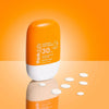 Orange and white bottle of think daily Everyday Sun Serum SPF 30 on an orange background