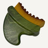 A jade lymphatic massage tool with a green polished jade stone handle and a yellow bristle brush on top, shown on a white background.