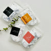 Five packets of bath salts with colorful labels on a white background