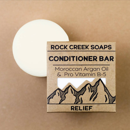 Rock Creek Soaps conditioner bar with packaging on a brown background