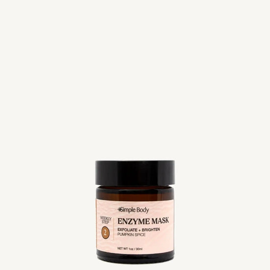 A black and clear glass jar with a label that reads 'Enzyme Mask' and indicates the product is for exfoliating and brightening the skin. The jar is set against a white background.