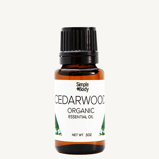 Bottle of Simple Body Cedarwood Organic Essential Oil on a white background