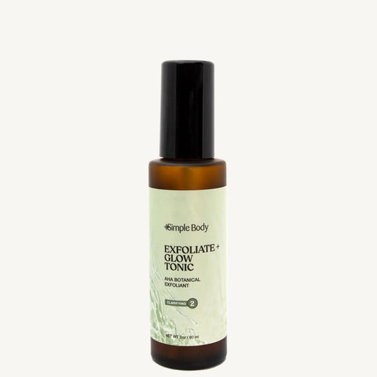 A recyclable glass spray bottle labeled 'Exfoliate + Glow Tonic' by Simple Body, designed for skincare.