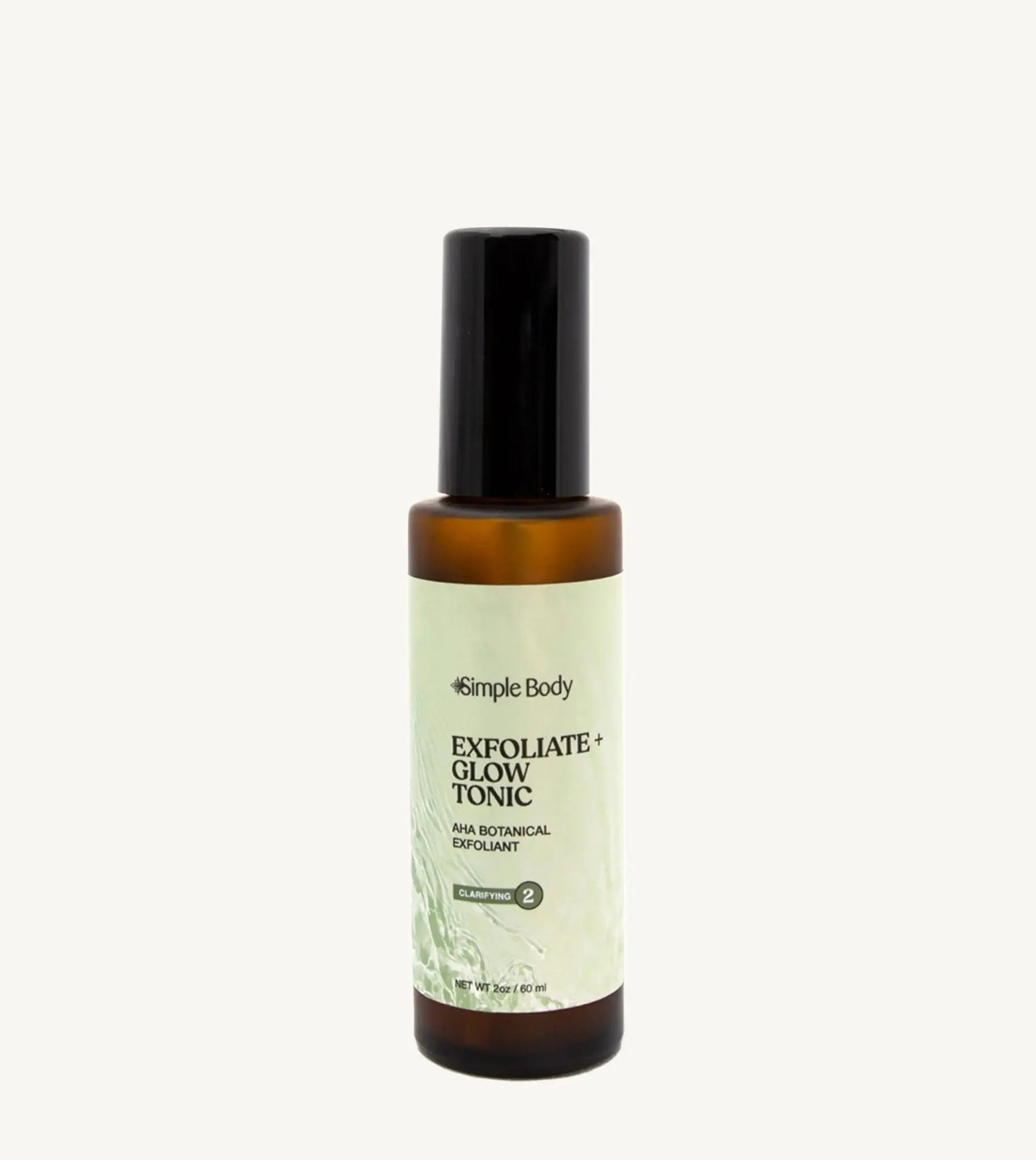 A recyclable glass spray bottle labeled 'Exfoliate + Glow Tonic' by Simple Body, designed for skincare.
