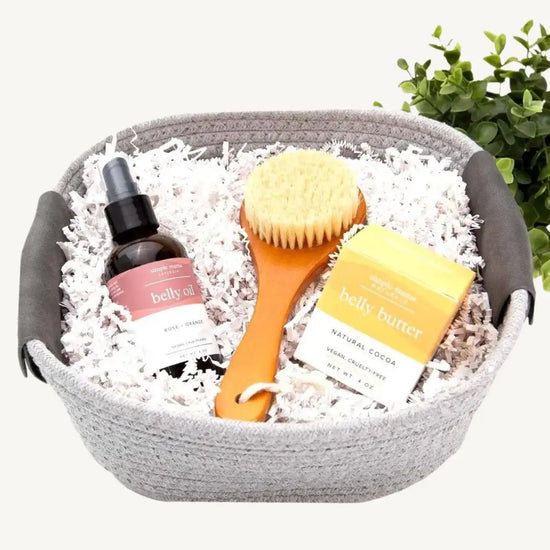 A gift basket containing a hydrating belly oil, a belly butter, and a dry brush, packaged in a reusable cotton rope basket.